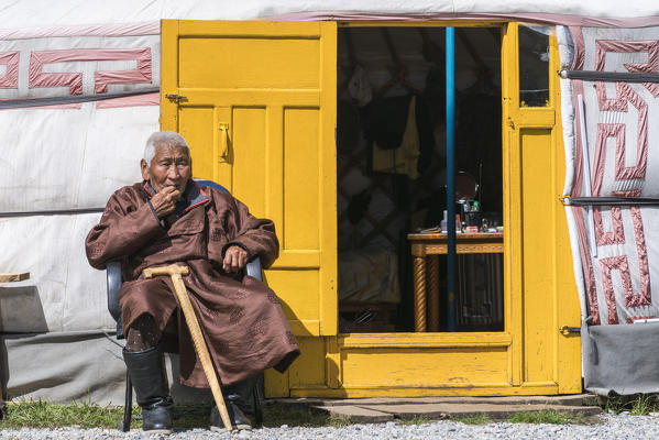 Mongolian nomadic old man sitting at the entrance of his ger. Hovsgol province, Mongolia.