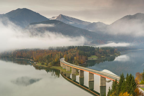 Sylvenstein Lake and bridge surrounded by the morning mist. Bad Tölz-Wolfratshausen district, Bavaria, Germany.