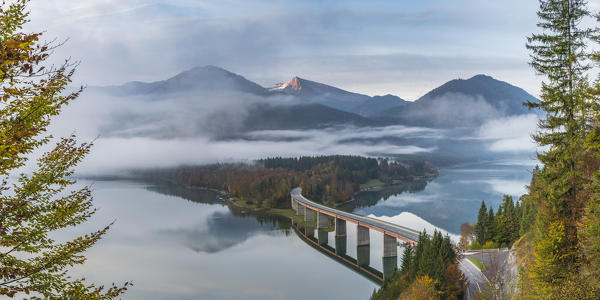 Sylvenstein Lake and bridge surrounded by the morning mist. Bad Tölz-Wolfratshausen district, Bavaria, Germany.
