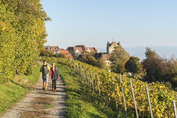 Couple walking on a pathway towards the town center. Meersburg, Baden-Württemberg, Germany.