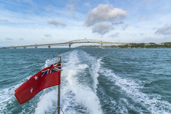The New Zealand Red Ensign and Auckland Harbour Bridge in the background. Auckland City, Auckland region, North Island, New Zealand.