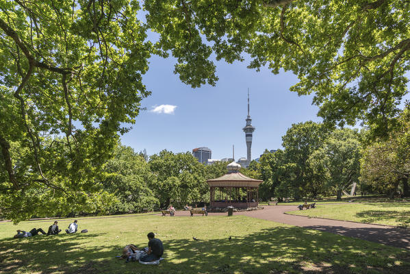 People relaxing on the gardens near the band rotunda in Albert Park. Auckland City, Auckland region, North Island, New Zealand.