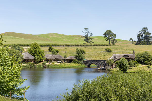 Lake, bridge and The Green Dragon Inn. Hobbiton Movie Set, Matamata, Waikato region, North Island, New Zealand.