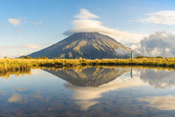 Woman staring at Mount Taranaki. Egmont National Park, New Plymouth district, Taranaki region, North Island, New Zealand. (MR)