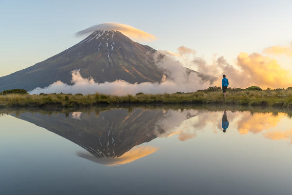 Man staring at Mount Taranaki at sunset. Egmont National Park, New Plymouth district, Taranaki region, North Island, New Zealand. (MR)