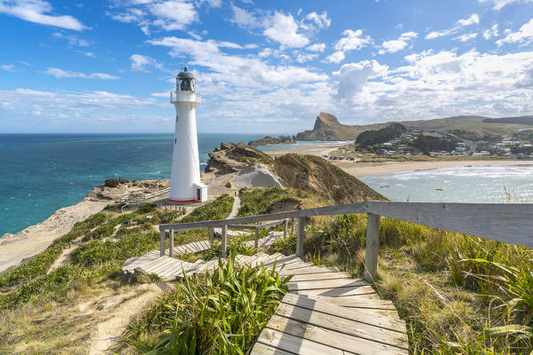 Castlepoint lighthouse and Castle Rock in the background. Castlepoint, Wairarapa region, North Island, New Zealand.
