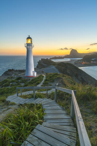 Castlepoint lighthouse lit at dusk. Castlepoint, Wairarapa region, North Island, New Zealand.