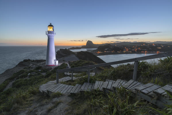 Castlepoint lighthouse lit in purple at dusk. Castlepoint, Wairarapa region, North Island, New Zealand.