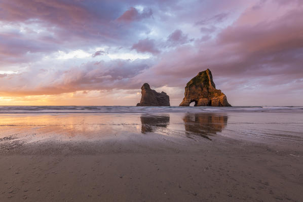 Sunset clouds above Archway Islands. Wharariki beach, Puponga, Tasman district, South Island, New Zealand.