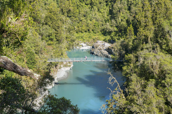Couple on a boardwalk over Hokitika river. Hokitika, West Coast region, South Island, New Zealand.