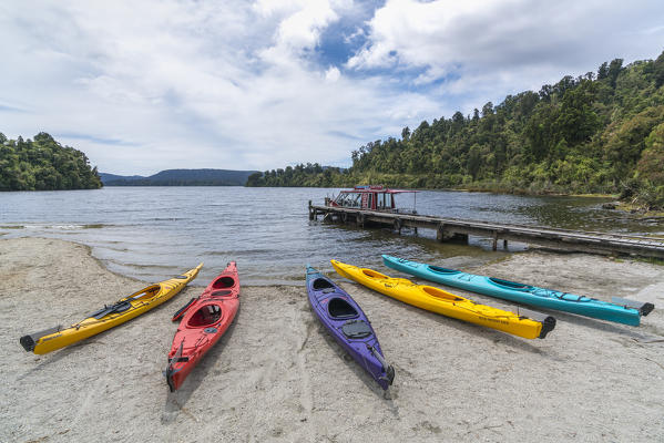 Kayaks on the shore of Lake Mapourika. Waiho, Westland district, West Coast region, South Island, New Zealand.