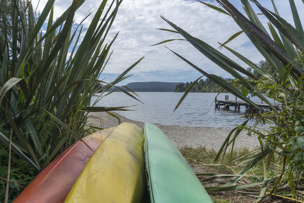 Kayaks on the shore of Lake Mapourika. Waiho, Westland district, West Coast region, South Island, New Zealand.