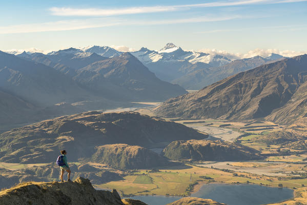 Woman admiring Lake Wanaka and Mount Aspiring NP from Roys Peak track. Wanaka, Queenstown Lakes district, Otago region, South Island, New Zealand. (MR)