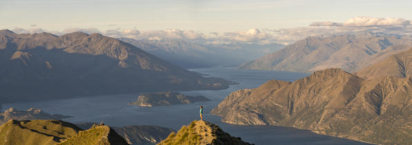 Woman admiring the landscape from Roys Peak lookout. Wanaka, Queenstown Lakes district, Otago region, South Island, New Zealand.