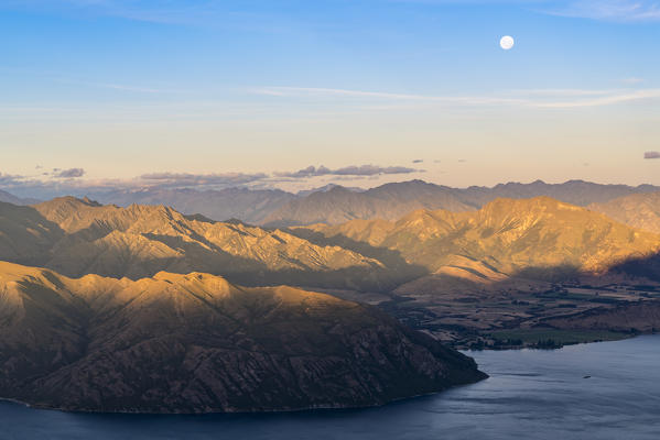 Moon over Lake Wanaka at sunset shot from Roys Peak track. Wanaka, Queenstown Lakes district, Otago region, South Island, New Zealand.