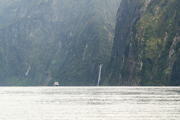 Boat and Stirling Falls at Milford Sound. Fiordland NP, Southland district, Southland region, South Island, New Zealand.