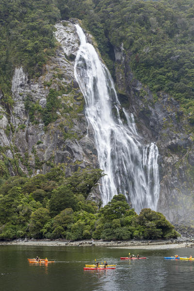 People kayaking around Bowen Falls in Milford Sound in summer. Fiordland NP, Southland district, Southland region, South Island, New Zealand.