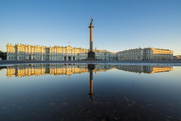 Winter Palace and Alexander Column reflecting on a pond after the rain in Palace Square at dawn. Saint Petersburg, Russia.