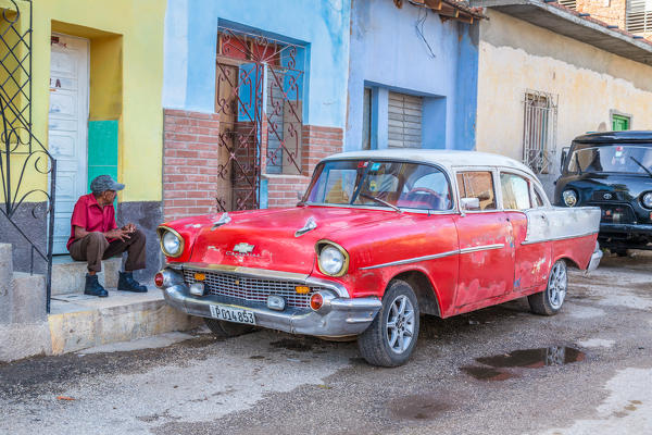 Man and classic American vintage car in Trinidad,  Trinidad and Sancti Spiritus Province, Cuba