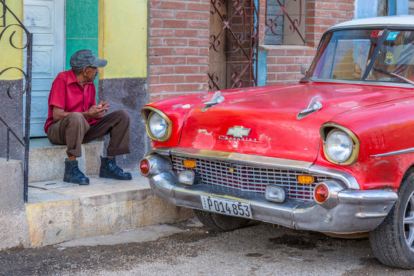 Man and classic American vintage car in Trinidad,  Trinidad and Sancti Spiritus Province, Cuba