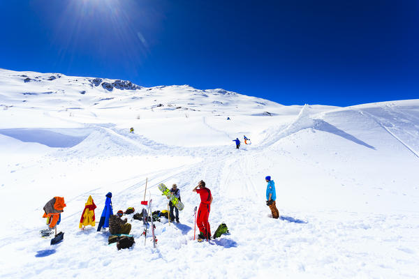 Skiers and snowboarders getting ready to hit the jump in Livigno, Lombardy, Italy, Europe