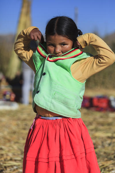 Child leaving on the Uros floating islands on Lake Titicaca, Puno, Peru