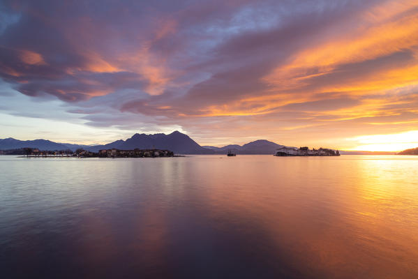 View of the Borromean Islands, Isola dei Pescatori and Isola Bella, from the shore of Baveno in a winter sunrise, Verbano Cusio Ossola, Lago Maggiore, Piedmont, Italy.