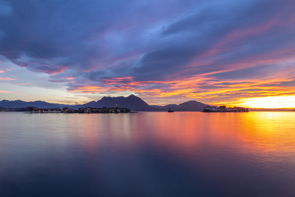View of the Borromean Islands, Isola dei Pescatori and Isola Bella, from the shore of Baveno in a winter sunrise, Verbano Cusio Ossola, Lago Maggiore, Piedmont, Italy.