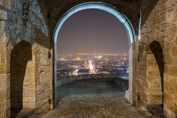 View of the city of Bergamo from Porta San Giacomo old city doors in Upper Town (Città Alta) at night. Bergamo, Lombardy, Italy.