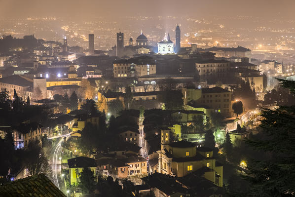 View of the rooftops, churches and towers of the Upper Town (Città Alta) of Bergamo city at night. Bergamo, Lombardy, Italy.