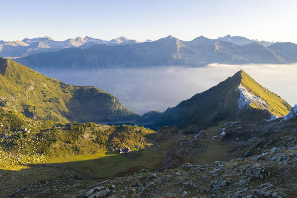 Aerial view of a foggy sunrise on the Alpe Campolungo, valley of Lago Tremorgio, Valle Leventina and Pizzo del Sole. Rodi, Prato Leventina, Valle Leventina, Canton Ticino, Switzerland.