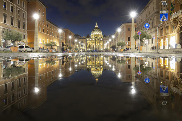 View of the Basilica di San Pietro cathedral reflected on a pond in Via della Conciliazione. Rome, Rome district, Lazio, Europe, Italy.