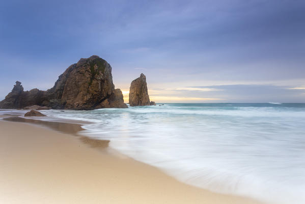 Sunset on the beach of Praia da Ursa with it's giant boulders. Cabo da Roca, Colares, Sintra, Portugal, Europe.