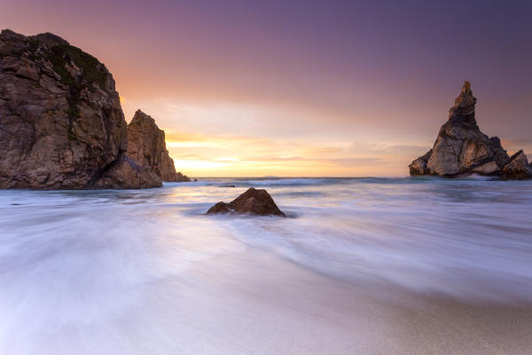 Sunset on the beach of Praia da Ursa with it's giant boulders. Cabo da Roca, Colares, Sintra, Portugal, Europe.