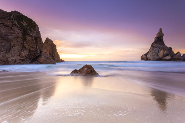 Sunset on the beach of Praia da Ursa with it's giant boulders. Cabo da Roca, Colares, Sintra, Portugal, Europe.