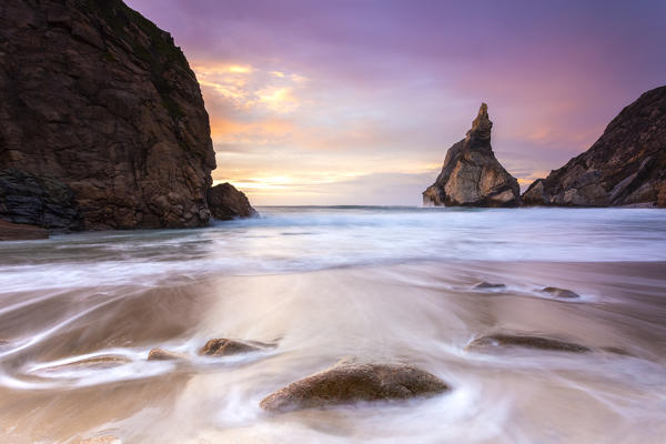 Sunset on the beach of Praia da Ursa,with the giant Ursa and Gigante boulders. Cabo da Roca, Colares, Sintra, Portugal, Europe.