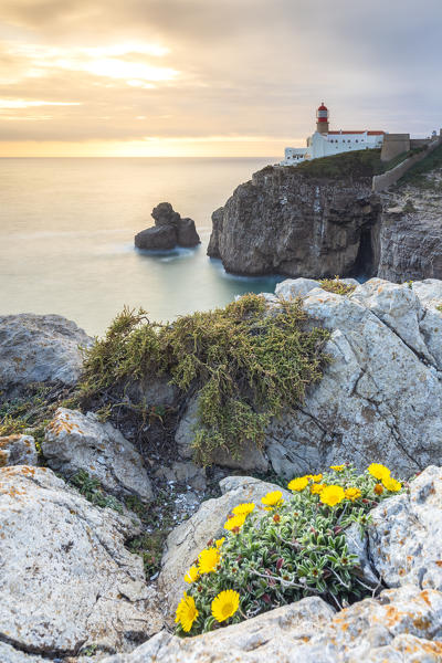 The cliffs and lighthouse of Cabo De San Vicente at sunset, overlooking the Atlantic Ocean. Sagres, Vila do Bispo, Algarve, Portugal, Europe.