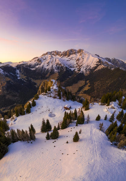 Aerial view of the Presolana covered in snow, Malga Scanapà and the iron cross from Mount Scanapà during a winter sunset. Castione della Presolana, Val Seriana, Bergamo district, Lombardy, Italy.
