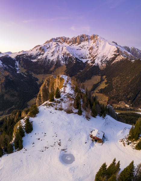 Aerial view of the Presolana covered in snow, Malga Scanapà and the iron cross from Mount Scanapà during a winter sunset. Castione della Presolana, Val Seriana, Bergamo district, Lombardy, Italy.