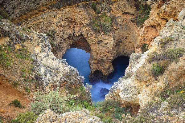 Heart shaped caves and arches at the yellow cliffs of Ponta da Piedade. Lagos, Algarve, Portugal, Europe.
