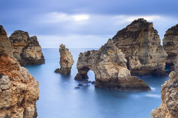 Cloudy sunrise at the yellow and red cliffs of Ponta da Piedade. Lagos, Algarve, Portugal, Europe.