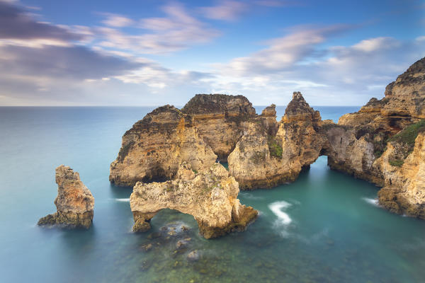 Cloudy sunrise at the yellow and red cliffs of Ponta da Piedade. Lagos, Algarve, Portugal, Europe.