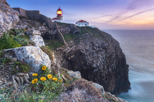The cliffs and lighthouse of Cabo De San Vicente at sunset, overlooking the Atlantic Ocean. Sagres, Vila do Bispo, Algarve, Portugal, Europe.