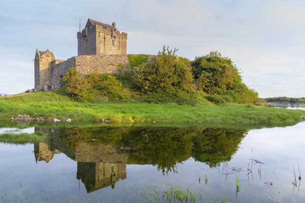 Sunrise at the Dunguaire Castle reflected in its moat. County Galway, Connacht province, Ireland, Europe.