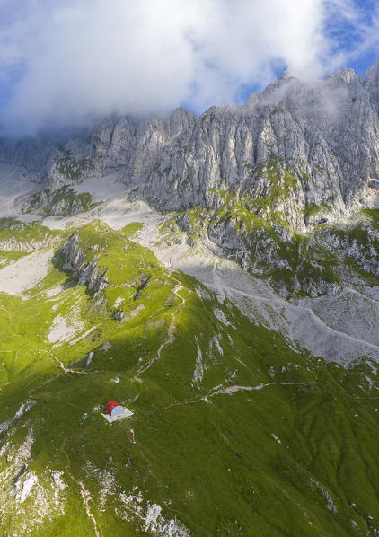 Aerial view of the Presolana covered in clouds and the Città di Clusone bivouac at it's foothills. Passo della Presolana, Castione della Presolana, Val Seriana, Bergamo district, Lombardy, Italy.