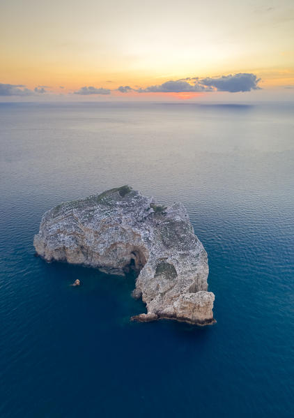 Aerial view of Isola Foradada island in front of the rocky promontory of Capo Caccia at sunset, Alghero,  Sassari district, Sardinia, Italy.