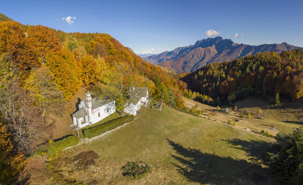 Aerial view of the autumnal colors at the Alpe Blitz church with a view over mount Limidario in the back. Craveggia, Valle Vigezzo, val d'Ossola, Verbano Cusio Ossola, Piedmont, Italy.