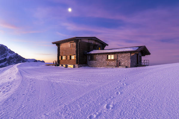 View of a colorful sunrise in front of the Rifugio Aquila in winter. Colere, Val di Scalve, Bergamo district, Lombardy, Italy, Southern Europe.