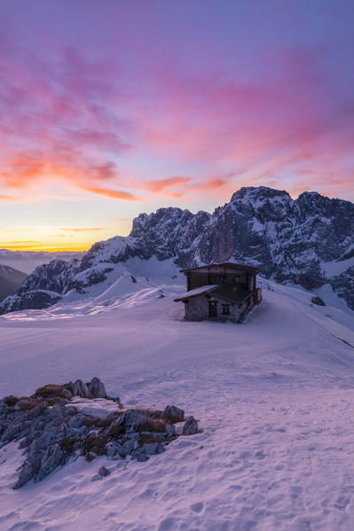 View of the snow-covered north face of the Presolana mountain in winter at sunrise with the Aquila refuge. Colere, Val di Scalve, Bergamo district, Lombardy, Italy, Southern Europe.