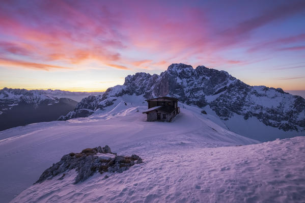 View of the snow-covered north face of the Presolana mountain in winter at sunrise with the Aquila refuge. Colere, Val di Scalve, Bergamo district, Lombardy, Italy, Southern Europe.